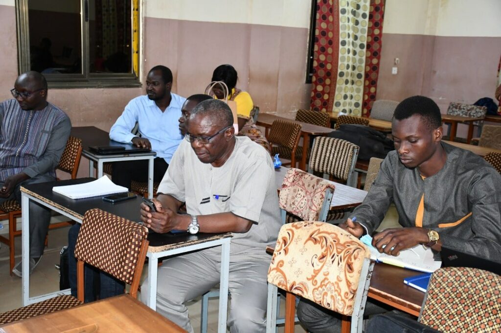 Candid shot of university presenters talking with students in a bright hall