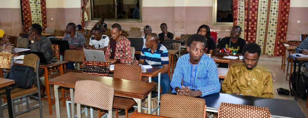 Presentation slides shown on a screen in a large academic lecture hall
